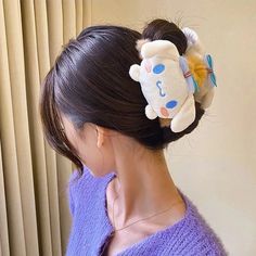 a woman wearing a hair clip with a stuffed animal on it's back side