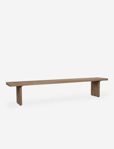 a wooden bench sitting on top of a white wall