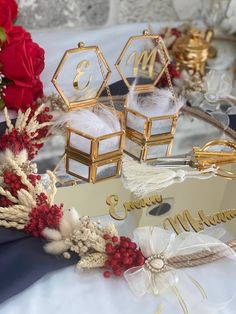 two wedding rings are sitting on top of a table with red flowers and other decorations