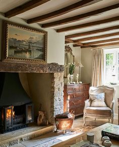 a living room filled with furniture and a fire place in front of a painting on the wall