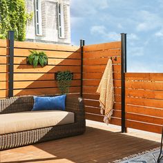 an outdoor patio with wooden slats and plants on the decking area, next to a fence