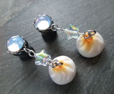 "This pair of dangle plugs features white opal round glass gems, set in silver plated closed scalloped frames. Dangling from each plug is a cute resin steamed bun charm and clear glass star beads with a rainbow finish. These are available in the following sizes and styles: 12g (2mm) - Steel Screw Back 10g (2.4mm) - Steel Screw Back 8g (3mm) - Steel Screw Back 8g (3mm) - Acrylic Screw Back 6g (4mm) - Steel Screw Back 6g (4mm) - Acrylic Screw Back 4g (5mm) - Black Acrylic Screw Back 4g (5mm) - Ste Adjustable White Dangle Plug Earrings, White Hypoallergenic Dangle Cartilage Earrings, Adjustable Hypoallergenic White Plug Earrings, White Dangle Cartilage Earrings, Unique White Plug Earrings, Dangle Plugs, Glass Stars, Steamed Buns, Food Jewelry