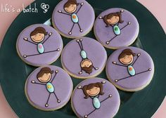 cookies decorated with purple icing and images of women on them are sitting on a green plate