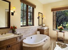 a bathroom with a large jacuzzi tub next to a sink and window in it