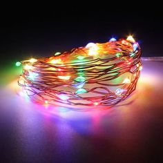 an assortment of multicolored christmas lights on a table with the light turned on