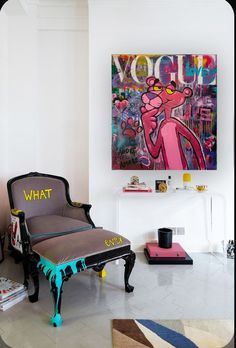 a living room filled with furniture and a painting on the wall above it's head