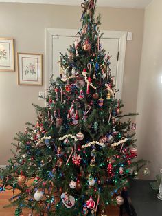 a decorated christmas tree sitting on top of a hard wood floor