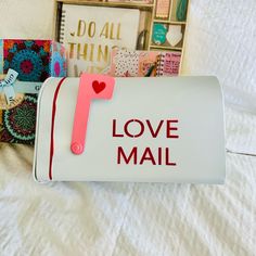 mailbox with love mail attached to it sitting on a bed next to other items