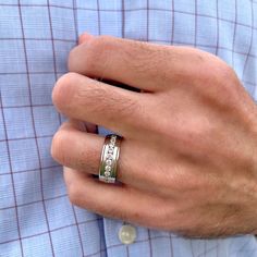 a man's hand with a ring on his left and a blue shirt on the right