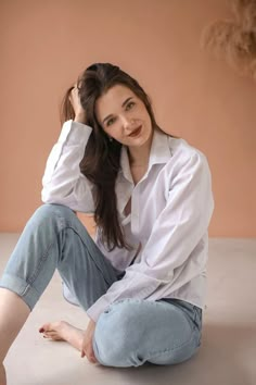 a woman sitting on the ground posing for a photo