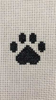 a cross stitch pattern with black and white paw prints on the front of a shirt