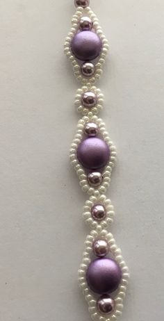 a white and purple beaded bracelet with pearls