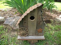 a birdhouse made out of wood with wheels and stars on the roof is shown