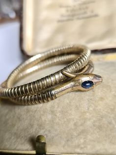 Elegant bangle made of doublè with a movable core so that the bracelet adjusts to the size of your breathing. On its head, the snake wears a sapphire cabochon in a great blue. Unfortunately, the condition is no longer so good, but in my opinion, this really gives the bracelet character. Dimensions head approx. 25 x 7 mm Diameter unstretched approx. 5.3 cm All items in my shop are sold according to §25a UStG differential taxation. An invoice prepared by Etsy is included with every purchase. If yo Vintage Snake-shape Jewelry For Formal Occasions, Vintage Yellow Gold Snake Jewelry, Antique Gold Snake-shaped Jewelry, Antique Gold Snake Ring For Formal Occasions, Antique Snake-shaped Yellow Gold Jewelry, Serpent Art, Snake Bangle, Sapphire Cabochon, Bangles Making