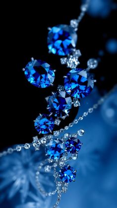 a blue diamond necklace is shown on a black background with water droplets and bubbles around it