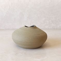 a white vase sitting on top of a table