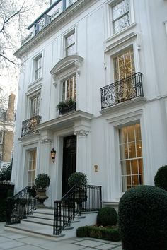 Elegant white stucco exterior navy front door decorative glass panel wooden carving wrought iron railing White Classic House, Grey Stucco House Exterior, Facade Design Classic, Condo Exterior, French Style House, White Stucco Exterior, Navy Door, White Stucco House