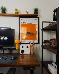 a desk with a monitor, keyboard and mouse on it in front of a white wall