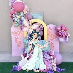 an elaborate balloon sculpture with a princess standing in front of it