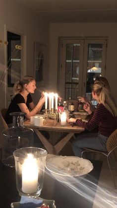 two women sitting at a table with candles in front of them