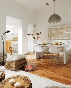 a dining room with white chairs and wooden floors