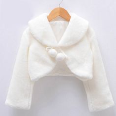 Dated back in the 1850s, where bolero jackets were used in bullfights, it has become a fashion style and was carried to the crinoline. This Fleece Pompon Long Sleeves Bolero will complement any girl's dress and will definitely add elegance, but at the same time, feel more convenient than a long jacket. It can also be used in cold weather as it is made of fleece material - warm and cozy. Features: Long sleeves bolero jacket. Shawl collar design. Solid pattern, O-neck style. With cute pompons that Faux Fur Bolero, Girls Cape, Faux Fur Shrug, White Fur Coat, Fur Shrug, Girl Sleeves, Wedding Girl, Long Sleeve Kids, Bolero Jacket