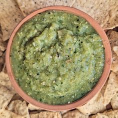 a bowl of guacamole surrounded by tortilla chips