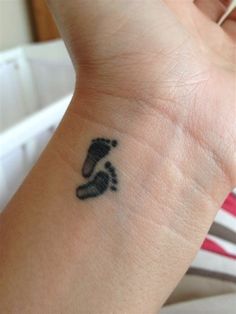 a person's wrist with a small foot print on the left side of their arm