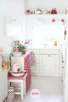 a white kitchen with red and white decor