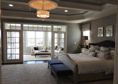 a large bed sitting in the middle of a living room next to a doorway with french doors