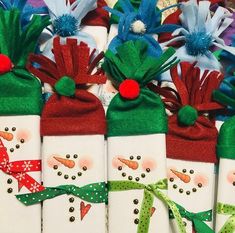 christmas gift bags with snowmen on them and ribbons tied around the top, all decorated in different colors