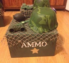 camouflaged hats and binoculars are on display in the corner of a room with wooden flooring