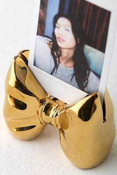 a gold bowknoted photo holder holds an image of a woman's face