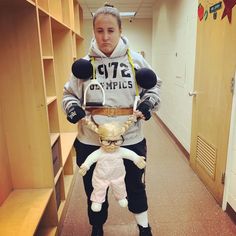 a woman is standing in a hallway holding a stuffed animal