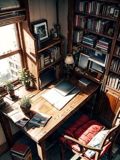 a wooden desk sitting next to a window filled with books