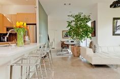 a living room filled with furniture next to a kitchen