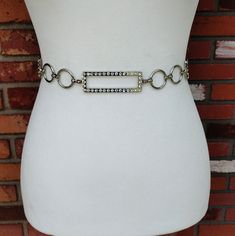 This is a vintage silver metal rhinestone chain belt with rectangular and circle shaped links. The rectangle links are decorated with clear round sparkly rhinestones. It has an adjustable chain and a hook closure. It's in excellent condition. Measurements: Total length 48.5 inches Adjusting chain length 21 inches Adjustable from 28 to 46 inches Width 1 inch at widest point Price includes free shipping within the USA. Please visit my other Etsy shop for vintage jewelry: https://www.etsy.com/shop/BunnyLazuli Virtually everything we sell has been previously worn/used so it is likely to show some degree of evidence of that. There will be a note in the description if there is anything more than normal, minor wear. Items are described as vintage and identified by the best of my ability as we are Silver Chain Strap Belt For Evening, Elegant Silver Crystal Chain Belt, Vintage Silver Chain Belt For Party, Silver Crystal Chain Belt For Party, Elegant Silver Chain Metal Belt, Chic Silver Metal Chain Belt, Elegant Silver Chain Belt, Rectangular Silver Glamorous Jewelry, Formal Silver Chain Belt