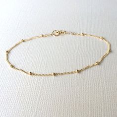 **Please note: My current production time is 5-10 business days.**  Satellite BraceletTiny gold beads are scattered on a very dainty 14k gold fill curb chain. Securely wire wrapped at the ends with a small 14k gold filled clasp.  Modern, simple and great for layering with other bracelets.Details:~Gold beads measure 1mm.~Dainty chain and findings are 14k gold fill.~Bracelet length is customizable from 6-8 inches.Every Marigold Mary purchase will arrive beautifully packaged in a small gift box.Vie Dainty Yellow Gold Beaded Bracelets In 14k Gold Filled, Gold Beaded Chain Bracelet In 14k Gold Filled, Dainty Gold-plated Bracelet With Round Beads, Minimalist Satellite Chain Bracelet With Round Beads, Everyday Chain Bracelet With Round Beads, Gold Satellite Chain Bracelet, 14k Gold Filled, 14k Gold Filled Satellite Chain Bracelet, Gold 14k Gold-filled Satellite Chain Bracelet, Gold Chain Bracelet With Delicate Round Beads