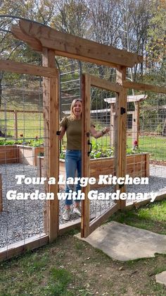 a woman standing in front of a chicken coop with her arms out and hands on the door