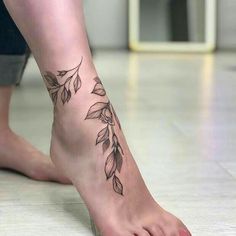 a close up of a person's foot with leaves on it