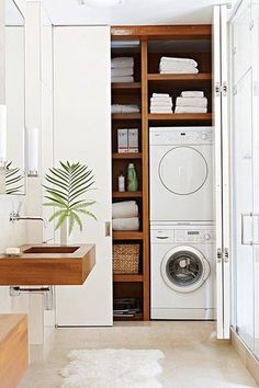 a washer and dryer in a small room with shelves on either side of the washer and dryer