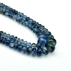 two strands of blue glass beads on a white surface