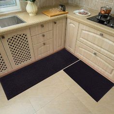 a kitchen with beige cabinets and tile flooring next to a stove top oven under a window