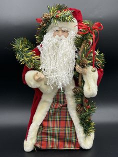 a santa clause figurine with pine cones and firs on his chest, holding a staff