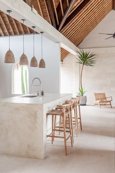 a kitchen with an island and stools next to it in the middle of a room