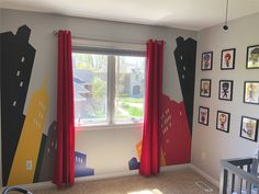 a child's room with red curtains and pictures on the wall