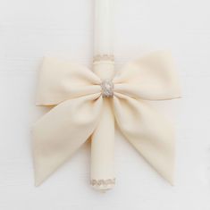 a white candle with a large bow on it