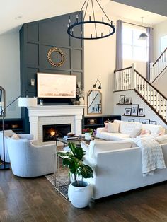 a living room filled with furniture and a fire place in front of a tv mounted on a wall