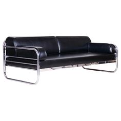 a black leather couch sitting on top of a metal frame