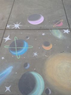 the sidewalk is painted with chalk and has different colored planets on it, as well as stars